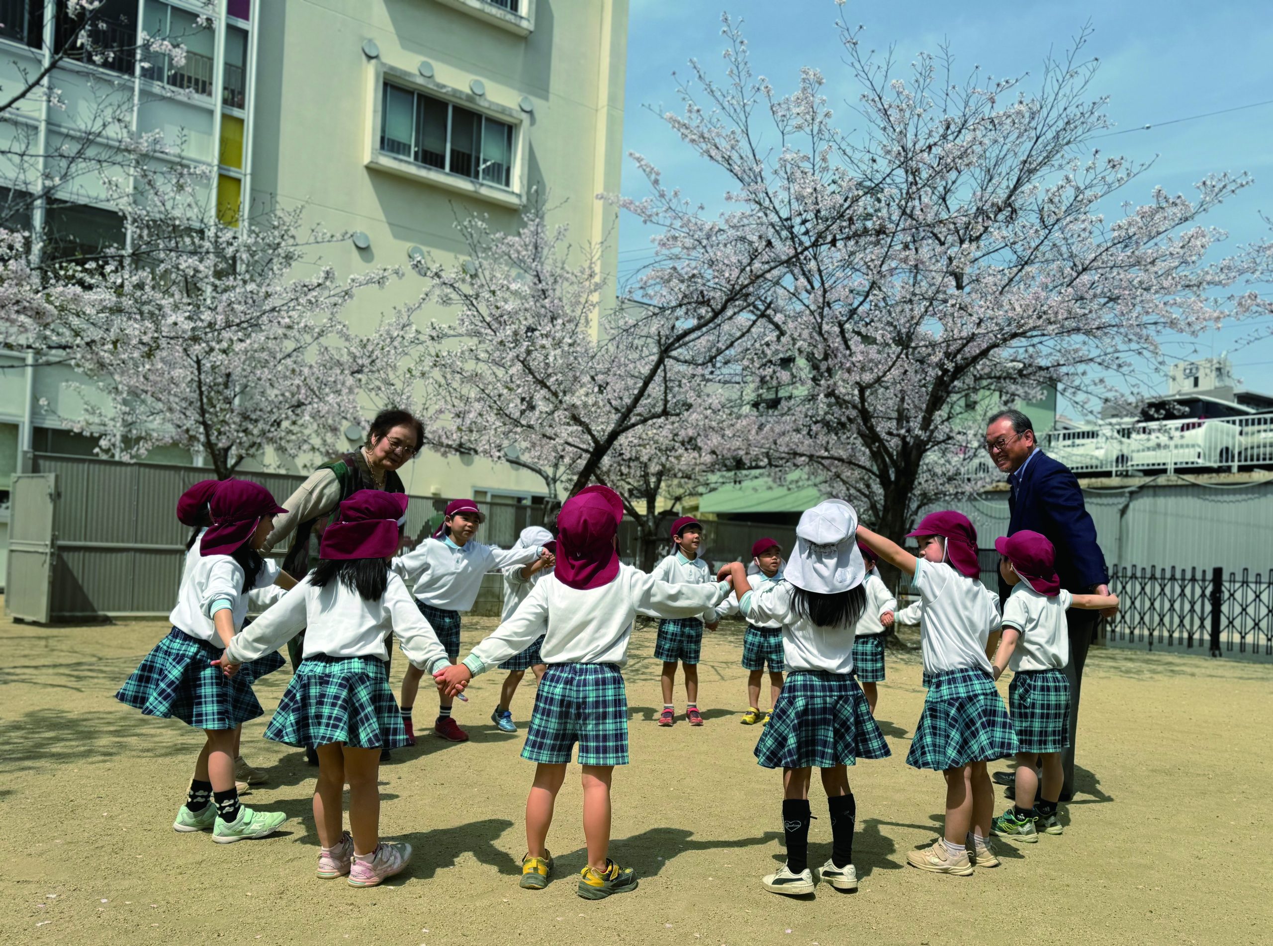 桜の下、子どもたちと遊ぶ園長